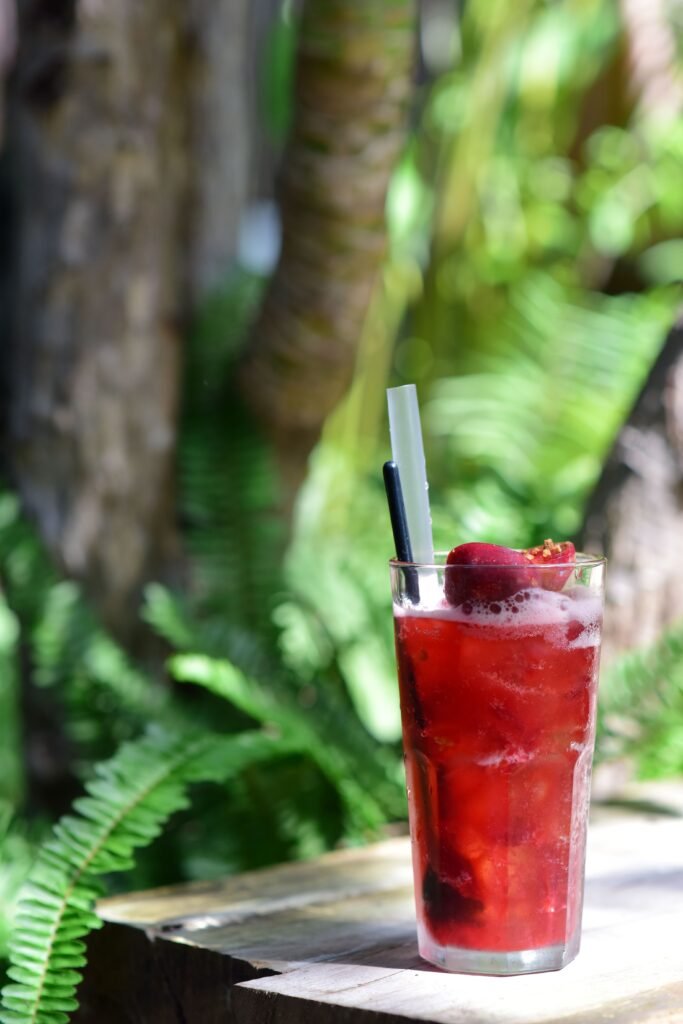 pexels-photo-32857360-32857360 Vibrant raspberry cocktail on wooden table with fresh outdoors ambience, perfect for summer refreshment.
