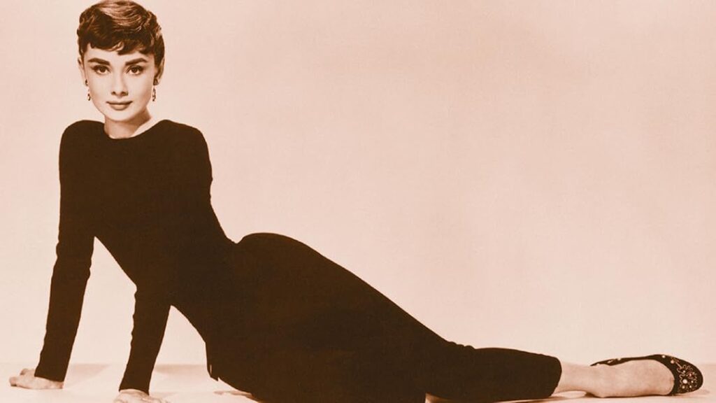 Old picture of Audrey Hepburn as she poses in her black body hugging dress